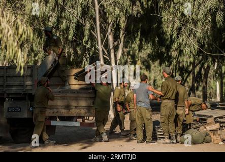 (140820) -- FRONTIERA DI GAZA, 20 agosto 2014 -- i soldati israeliani caricano i letti di campo su un camion in un'area di dispiegamento dell'esercito nel sud di Israele al confine con la Striscia di Gaza, il 20 agosto 2014. Israele intensificherà l'offensiva nella Striscia di Gaza fino a quando il lancio di razzi da lì in Israele si fermerà, ha detto mercoledì il primo ministro Benjamin Netanyahu, in risposta ai rinnovati attacchi missilistici di Gaza contro Israele centrale e meridionale all'inizio della giornata. ) ISRAELE-GAZA-OFFENSIVA-INTENSIFICARE LixRui PUBLICATIONxNOTxINxCHN frontiera di Gaza 20 agosto 2014 soldati israeliani caricano letti da campo su un camion ALL'area dell'Esercito nel sud di Israele Foto Stock