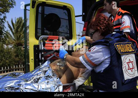 Un israeliano ferito arriva al Barzilai Medical Center nella città israeliana meridionale di Ashkelon, 10 chilometri a nord della Striscia di Gaza, dopo essere rimasto ferito a seguito di un incendio da Gaza al valico di Erez, il 24 agosto 2014. Domenica il primo ministro israeliano Benjamin Netanyahu ha dichiarato che l'operazione militare a Gaza proseguirà fino al raggiungimento degli obiettivi di sicurezza di Israele. () (lmz) ISRAEL-GAZA STRIP-OPERATION-PM Xinhua PUBLICATIONxNOTxINxCHN un uomo israeliano ferito arriva AL Centro medico nella città israeliana meridionale di Ashkelon a 10 chilometri a nord della Striscia di Gaza dopo che lui ha ferito follo Foto Stock