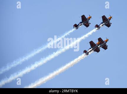 FAKU, 27 agosto 2014 -- tre aerei del Red Bull Aerobatic Team volano in formazione in uno spettacolo aereo a Faku, provincia di Liaoning, Cina nordorientale, 27 agosto 2014. Il Red Bull Aerobatic Team of China, la prima squadra di acrobazie illimitate della nazione, è stata fondata dal pilota professionista Zhao Wei il 20 settembre 2013. Oltre a Zhao, i membri della squadra sono tutti sudafricani. Il team ha quattro aerei XA 42, gli aerei acrobatici di livello superiore che consentono a un pilota di volare ad altitudini molto più basse e a velocità più lente e quindi forniscono un impatto visivo molto più forte per gli spettatori. La squadra acrobatica si sta preparando Foto Stock