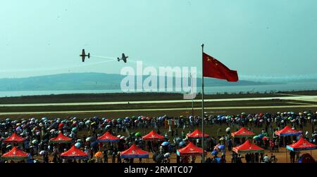 FAKU, 27 agosto 2014 -- due aerei del Red Bull Aerobatic Team volano in formazione in uno spettacolo aereo a Faku, provincia di Liaoning, Cina nordorientale, 27 agosto 2014. Il Red Bull Aerobatic Team of China, la prima squadra di acrobazie illimitate della nazione, è stata fondata dal pilota professionista Zhao Wei il 20 settembre 2013. Oltre a Zhao, i membri della squadra sono tutti sudafricani. Il team ha quattro aerei XA 42, gli aerei acrobatici di livello superiore che consentono a un pilota di volare ad altitudini molto più basse e a velocità più lente e quindi forniscono un impatto visivo molto più forte per gli spettatori. La squadra acrobatica si sta preparando per la t Foto Stock