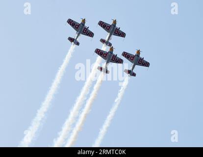 FAKU, 27 agosto 2014 -- quattro aerei del Red Bull Aerobatic Team volano in formazione in uno spettacolo aereo a Faku, provincia di Liaoning della Cina nordorientale, 27 agosto 2014. Il Red Bull Aerobatic Team of China, la prima squadra di acrobazie illimitate della nazione, è stata fondata dal pilota professionista Zhao Wei il 20 settembre 2013. Oltre a Zhao, i membri della squadra sono tutti sudafricani. Il team ha quattro aerei XA 42, gli aerei acrobatici di livello superiore che consentono a un pilota di volare ad altitudini molto più basse e a velocità più lente e quindi forniscono un impatto visivo molto più forte per gli spettatori. La squadra acrobatica si sta preparando Foto Stock