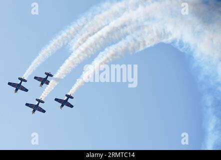 FAKU, 27 agosto 2014 -- quattro aerei del Red Bull Aerobatic Team volano in formazione in uno spettacolo aereo a Faku, provincia di Liaoning della Cina nordorientale, 27 agosto 2014. Il Red Bull Aerobatic Team of China, la prima squadra di acrobazie illimitate della nazione, è stata fondata dal pilota professionista Zhao Wei il 20 settembre 2013. Oltre a Zhao, i membri della squadra sono tutti sudafricani. Il team ha quattro aerei XA 42, gli aerei acrobatici di livello superiore che consentono a un pilota di volare ad altitudini molto più basse e a velocità più lente e quindi forniscono un impatto visivo molto più forte per gli spettatori. La squadra acrobatica si sta preparando Foto Stock