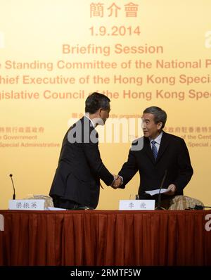 (140901) -- HONG KONG, 1 settembre 2014 -- li Fei (R), vice segretario generale del Comitato permanente del Congresso Nazionale del popolo (NPC), stringe la mano all'amministratore delegato di Hong Kong, C Y Leung, dopo un intervento nel corso di una sessione informativa riguardante la decisione del comitato permanente dell'NPC su questioni relative alla selezione del direttore esecutivo della regione amministrativa speciale di Hong Kong da parte del suffragio universale e al metodo di formazione il Consiglio legislativo della regione amministrativa speciale di Hong Kong nel 2016, a Hong Kong, Cina meridionale, 1 settembre 2014. ) (HDT) CHINA-HONG KONG-NPC-BRIEFING Foto Stock