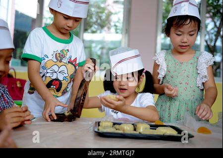 I bambini usano gli stampi per preparare le torte lunari a Hefei, capitale della provincia di Anhui della Cina orientale, 4 settembre 2014. Il Mid-Autumn Festival, che cade l'8 settembre di quest'anno, è un tradizionale festival cinese per riunioni di famiglia, durante il quale la gente potrà godersi la luna piena insieme e mangiare torte lunari - piccole torte rotonde con una varietà di ripieni. )(wjq) CHINA-ANHUI-HEFEI-MOONCAKE (CN) LiuxJunxi PUBLICATIONxNOTxINxCHN i bambini usano le muffe per preparare le torte lunari nella provincia di Anhui, capitale della Cina orientale, 4 settembre 2014 il Mid Autumn Festival che cade L'8 settembre di quest'anno È un tradizionale festival cinese per Foto Stock
