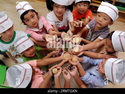 I bambini mostrano le torte lunari fatte da soli con gli stampi a Hefei, capitale della provincia di Anhui della Cina orientale, 4 settembre 2014. Il Mid-Autumn Festival, che cade l'8 settembre di quest'anno, è un tradizionale festival cinese per riunioni di famiglia, durante il quale la gente potrà godersi la luna piena insieme e mangiare torte lunari - piccole torte rotonde con una varietà di ripieni. )(wjq) CHINA-ANHUI-HEFEI-MOONCAKE (CN) LiuxJunxi PUBLICATIONxNOTxINxCHN Children Show Mooncakes fatti con le muffe da soli nella provincia di Anhui, capitale della Cina orientale, 4 settembre 2014 il Mid Autumn Festival che cade L'8 settembre di quest'anno È Foto Stock