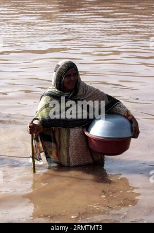 (140912) -- LAHORE, -- Una donna pakistana cammina in acque alluvionali con i propri stock vivi nel villaggio colpito dalle inondazioni di Chung vicino Lahore, Pakistan orientale, l'11 settembre 2014. Le truppe pakistane hanno usato elicotteri e barche per evacuare migliaia di sfollati dalle pianure del paese, dove infuriate inondazioni monsoniche hanno inondato altri villaggi giovedì. ) PAKISTAN-LAHORE-INONDAZIONE METEO JamilxAhmed PUBLICATIONxNOTxINxCHN Lahore una donna pakistana cammina in acqua alluvionale con le sue scorte vive nel villaggio di Chung vicino a Lahore Pakistan orientale L'11 settembre 2014 le truppe pakistane hanno usato elicotteri e Bo Foto Stock