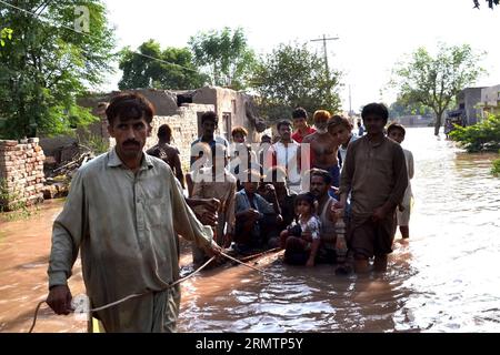 (140914) -- MULTAN, 14 settembre 2014 -- gli abitanti del villaggio pakistani colpiti dalle inondazioni si sono infiltrati nelle acque alluvionali di Sher Shah vicino al centro di Multan, 14 settembre 2014. Almeno 17 persone sono state uccise e altre 22 sono state salvate quando una barca che trasportava sposi, sposi e ospiti di nozze si è capovolta domenica nella città centrale del Pakistan di Multan, ha riferito i media locali. ( cy) PAKISTAN-MULTAN-INONDAZIONE Stringer PUBLICATIONxNOTxINxCHN Multan 14 settembre 2014 l'inondazione pakistana colpì gli abitanti del villaggio Calf attraverso le acque alluvionali a Sher Shah vicino al Pakistan centrale S Multan 14 settembre 2014 almeno 17 celebrità furono UCCISE e altre 22 W. Foto Stock