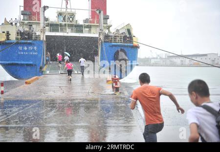 (140917) -- HAIKOU, 17 settembre 2014 -- i passeggeri salgono a bordo di una nave sotto pioggia al porto di Haikou a Haikou, capitale della provincia di Hainan della Cina meridionale, 17 settembre 2014. La navigazione sullo stretto di Qiongzhou è stata ripresa un giorno dopo che il tifone Kalmaegi è atterrato nella provincia dell'isola il martedì mattina. ) (Ry) CHINA-HAINAN-TYPHOON (CN ) YangxGuanyu PUBLICATIONxNOTxINxCHN Haikou 17 settembre 2014 passeggeri a bordo di una nave piovosa PRESSO il porto di Haikou a Haikou capitale della provincia di Hainan della Cina meridionale 17 settembre 2014 la spedizione SULLO stretto di Qiongzhou è stata ripresa un giorno dopo lo sbarco del tifone nella provincia o dell'Islanda Foto Stock