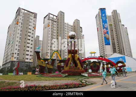 (140917) -- INCHEON, 17 settembre 2014 -- due volontari passano accanto ai aiuole nel villaggio di atleti a Incheon, Corea del Sud, 17 settembre 2014. L'Athletes Village si trova a 10 chilometri dal Main Press Center. Si compone di 22 condomini che forniscono un totale di 2.200 camere. I diciassettesimi Giochi asiatici si terranno dal 19 settembre al 4 ottobre. )(lz) (SP)COREA DEL SUD-INCHEON-ASIAN GAMES-ATHLETES VILLAGE Zhangxfan PUBLICATIONxNOTxINxCHN Incheon 17 settembre 2014 due volontari Passport by the Flower Beds nel Villaggio degli atleti di Incheon Corea del Sud 17 settembre 2014 il Villaggio degli atleti SI trova a 10 K. Foto Stock