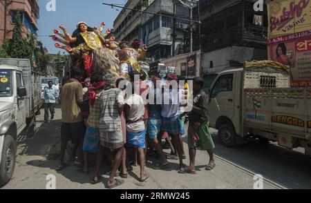 (140928) -- KOLKATA, 28 settembre 2014 -- i lavoratori indiani portano un idolo della dea indù Durga al suo luogo di culto per l'imminente festival Durga Puja a Calcutta, capitale dello stato indiano orientale del Bengala occidentale il 28 settembre 2014. Il festival Durga Puja coinvolge il culto della dea indù Durga, che simboleggia il potere e il trionfo del bene sul male nella mitologia indù. INDIA-KOLKATA-DURGA PUJA FESTIVAL-PREPARATION TumpaxMondal PUBLICATIONxNOTxINxCHN Kolkata settembre 28 2014 i lavoratori indiani portano a Idol della dea indù Durga al suo luogo di culto per il prossimo Durga Puja Festival a Kolkata Capit Foto Stock