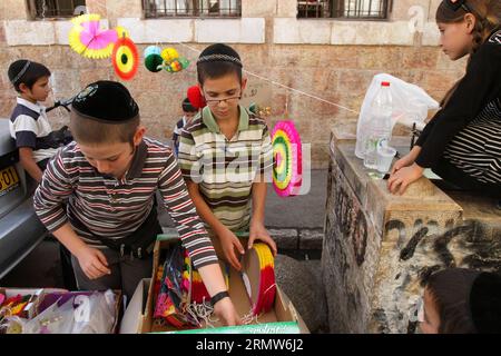 (141007) - GERUSALEMME, 7 ottobre 2014 -- gli ebrei ultra-ortodossi acquistano decorazioni per il loro Sukkot, cabine rituali utilizzate durante la festa ebraica di Sukkot in un quartiere religioso di Gerusalemme il 7 ottobre 2014. Gli ebrei osservanti costruiscono strutture temporanee per il festival di una settimana che commemora i 40 anni di viaggio nel deserto dopo l'Esodo dalla schiavitù in Egitto. Il Sukkot di quest'anno inizia giovedì. ) MEDIO ORIENTE-ISRAELE-SUKKOT-PREPARAZIONE GilxCohenxMagen PUBLICATIONxNOTxINxCHN Gerusalemme ottobre 7 2014 ebrei ultra ortodossi acquistano decorazioni per il loro stand rituale Sukkot utilizzato durante il Jewi Foto Stock