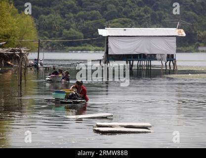 Le donne lavano i vestiti nelle acque inquinate del lago di Ilopango, 9 km a est di San Salvador, capitale di El Salvador, l'11 ottobre 2014. Il lago di Ilopango, di origine vulcanica, è inquinato da rifiuti di spazzatura, agrochimici e arsenico nei livelli sopra indicati, rispetto a quelli indicati dall'Organizzazione mondiale della sanità (OMS), e nonostante questa situazione, i residenti usano l'acqua per fare il lavoro quotidiano, come cucinare, lavare e fare il bagno, secondo la stampa locale. ) (Da) (fnc) EL SALVADOR-ILOPANGO-INQUINAMENTO AMBIENTALE OSCARxRIVERA PUBLICATIONxNOTxINxCHN donne Lavare abiti nelle acque inquinate del lago di Foto Stock