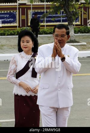 (141015) -- PHNOM PENH, 15 ottobre 2014 -- il primo ministro cambogiano Hun Sen (R) e sua moglie Bun Rany partecipano alla cerimonia che segna il secondo anniversario della morte del re padre Norodom Sihanouk a Phnom Penh 15 ottobre 2014. La Cambogia mercoledì ha commemorato il secondo anniversario della morte del più venerato re del paese padre Norodom Sihanouk offrendo elemosine ai monaci buddisti e rendendo omaggio alla sua statua. CAMBOGIA-PHNOM PENH-ANNIVERSARIO DELLA MORTE-RE PADRE SOVANNARA PUBLICATIONXNOTXINXCHN Foto Stock