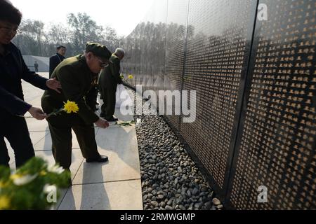 (141029) -- SHENYANG, 29 ottobre 2014 -- i veterani rendono omaggio a un monumento murario recante i nomi dei martiri della guerra di Corea (1950-1953) mentre assistono a una cerimonia di sepoltura per i resti di 437 soldati dell'esercito volontario del popolo cinese (CPVA) morti nella guerra di Corea, a Shenyang, capitale della provincia di Liaoning della Cina nord-orientale, 29 ottobre 2014. Una cerimonia di sepoltura per i resti di 437 soldati CPVA morti nella guerra di Corea si è tenuta mercoledì in un cimitero di martiri di guerra a Shenyang. I resti dei 437 martiri di guerra erano stati tenuti in Corea del Sud prima di essere restituiti in Cina lo scorso marzo. (lmm) Foto Stock