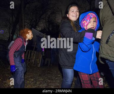 MONTREAL, 30 ottobre 2014 -- Una ragazza spaventata reagisce in Halloween Haunted Woods nella riserva Mohawk di Kahnawake vicino a Montreal, Canada, 30 ottobre 2014. Più di 10 volontari che indossano costumi spaventosi spaventano e intrattengono i visitatori durante la stagione di Halloween. L'attività di due giorni raccoglie anche cibo e donazioni per la banca alimentare locale. ) CANADA-MONTREAL-HALLOWEEN AndrewxSoong PUBLICATIONxNOTxINxCHN Montreal OCT 30 2014 una ragazza spaventata reagisce nel bosco infestato di Halloween NELLA riserva Mohawk di Kahnawake vicino a Montreal Canada OCT 30 2014 più di 10 volontari che indossano spavento Foto Stock