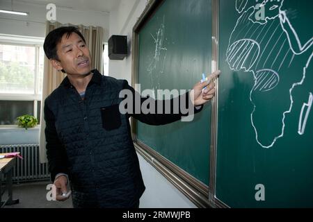 (141101) -- YINCHUAN, 31 ottobre 2014 -- Wang Boming discute la diffusione di Ebola utilizzando una mappa del mondo che ha calpestato durante una lezione di geografia alla Yingcai Junior High School di Yinchuan, capitale della regione autonoma Ningxia Hui della Cina nord-occidentale, 31 ottobre 2014. Wang Boming era un insegnante di arti, ma ora insegna geografia alla Yingcai Junior High School di Yinchuan. Durante la sua lezione, Wang può disegnare una mappa del mondo intatta sulla lavagna in quattro minuti, che considera un modo più diretto e coinvolgente per esporre gli studenti alla conoscenza geografica. Wang avrebbe anche istruito i suoi studenti sulla l Foto Stock