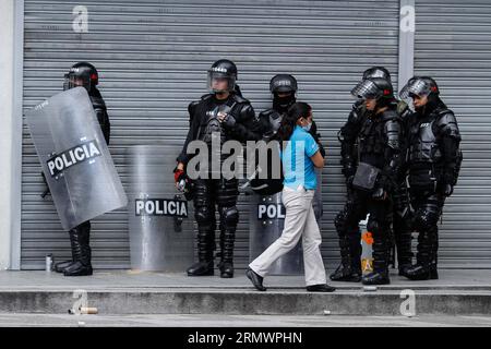 (141108) - BOGOTÀ, Un residente cammina di fronte ai poliziotti durante i disordini nell'Università Pedagogica di Bogotà, a Bogotà, capitale della Colombia, il 7 novembre 2014. Secondo la stampa locale, diverse persone incappucciate si ribellarono all'Università Pedagogica di Bogotà, che causò cinque feriti, tra cui due poliziotti con ustioni, due studenti e una guardia di sicurezza dell'università. ) (Dzl) COLOMBIA-BOGOTA-SOCIETY-UNREST JhonxPaz PUBLICATIONxNOTxINxCHN Bogota un residente cammina di fronte ai poliziotti durante i disordini nell'Università di Bogotà a Bogotà capitale della Colombia o Foto Stock