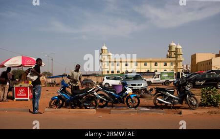 (141110) - OUAGADOUGOU, 10 novembre 2014. Un uomo aspetta che la sua moto venga lavata a Ouagadougou, capitale del Burkina Faso, 10 novembre 2014. (Dzl) BURKINA FASO-OUAGADOUGOU-STREET VIEW LixJing PUBLICATIONxNOTxINxCHN Ouagadougou Nov 10 2014 un uomo attende che la sua motocicletta venga lavata a Ouagadougou capitale del Burkina Faso Nov 10 2014 dzl Burkina Faso Ouagadougou Street View PUBLICATIONTxINxINxCHN Foto Stock