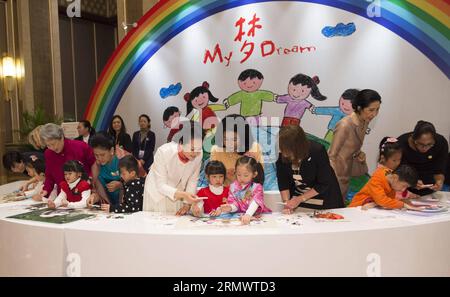 (141110) -- PECHINO, 10 novembre 2014 -- Peng Liyuan (in abito bianco), moglie del presidente cinese Xi Jinping, gioca a puzzle con bambini con problemi uditivi insieme ai coniugi di alcuni leader delle economie membri della cooperazione economica Asia-Pacifico (APEC) durante un'attività incentrata sulle questioni di sviluppo riguardanti i disabili, a Pechino, in Cina, 10 novembre 2014. )(hdt) (APEC 2014) CHINA-BEIJING-APEC-PENG LIYUAN-SPOSES-ACTIVITY (CN) HuangxJingwen PUBLICATIONxNOTxINxCHN Pechino Nov 10 2014 Peng Liyuan in abito bianco moglie del presidente cinese Xi Jinping SUONA Jigsaw Puzzle con C. Foto Stock