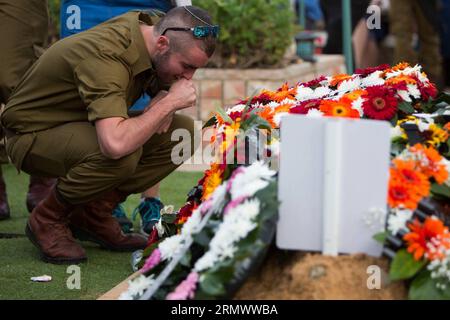 La gente piange mentre i soldati israeliani portano la bara drappeggiata della bandiera del loro compagno Almog Shiloni durante il suo funerale al cimitero militare sul Monte Herzl a Gerusalemme l'11 novembre 2014. Almog Shiloni, un soldato di 20 anni della città di Modiin, è stato pugnalato vicino a una stazione ferroviaria nel sud di Tel Aviv, capitale degli affari di Israele. MIDEAST-JERUSALEM-FUNERALE JINI PUBLICATIONxNOTxINxCHN celebrità Morne come soldati israeliani portano il Coffin drappeggiato bandiera del loro compagno Almog durante le sue funerali AL Cimitero militare SUL Monte Herzl a Gerusalemme L'11 novembre 2014 Almog un soldato di 20 anni dal Foto Stock