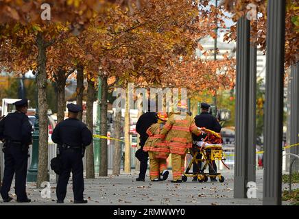 (141112) -- NEW YORK, 12 novembre 2014 -- i vigili del fuoco portano i lavavetri in un'ambulanza dopo un lavoro di soccorso al One World Trade Center di New York, Stati Uniti, 12 novembre 2014. Due lavavetri sono rimasti intrappolati per un'ora mercoledì su un ponteggio sospeso in alto sulla faccia del One World Trade Center, l'edificio più alto dell'emisfero occidentale. I vigili del fuoco hanno attraversato una finestra del 69° piano verso l'alto e li hanno tirati delicatamente all'interno per sicurezza. ) US-NEW YORK-ONE WORLD TRADE CENTER-ACCIDENT-WINDOW-WASHER WangxLei PUBLICATIONxNOTxINxCHN New York 12 novembre 2014 i vigili del fuoco portano il lavavetro Foto Stock
