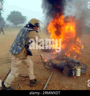 (141113) - GWALIOR, 12 novembre 2014 - Un poliziotto cerca di spegnere il fuoco nella città di Gwalior, in Madhya Pradesh, India, il 12 novembre 2014. Almeno sei persone sono rimaste ferite in una fuga che è scoppiata dopo la cancellazione di un viaggio di reclutamento dell'esercito indiano nello stato centrale del Madhya Pradesh mercoledì, ha detto un alto funzionario di polizia. ) (Dzl) INDIA-GWALIOR-VIOLENCE Stringer PUBLICATIONxNOTxINxCHN Gwalior 12 novembre 2014 un poliziotto cerca di inondare il fuoco nella città di Gwalior nel Madhya Pradesh India IL 12 novembre 2014 almeno sei celebrità sono rimaste ferite in uno Stampede che è scoppiato dopo la cancellazione di To Indian Foto Stock