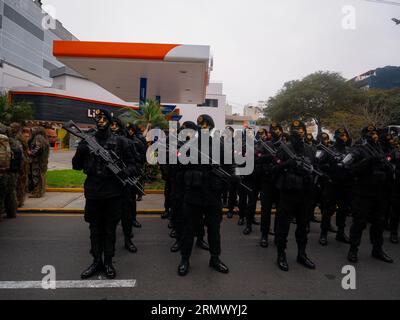 Lima, Perù - luglio 29 2023: Giovani uomini peruviani vestiti di nero con il volto nero e giallo dipinto Hold a Gun in the Independence Day Military Parade Foto Stock