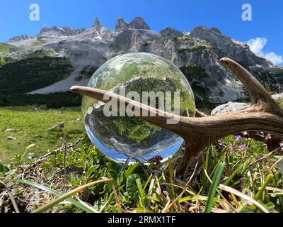 Natura morta degli imponenti palchi di roebuck (trofeo di caccia), accanto alla sfera dell'obiettivo, alla sfera di cristallo, con riflessi della valle Gauertal (Montafon, Vorarlberg) Foto Stock