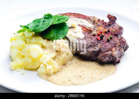 bistecca di manzo con salsa, purè di patate e foglie di spinaci Foto Stock