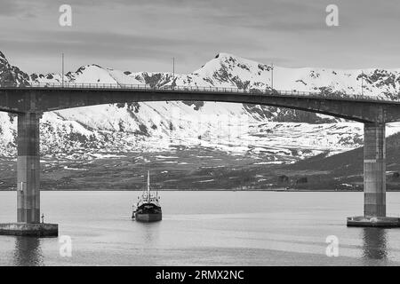 Foto in bianco e nero della draga di aspirazione del tubo flessibile posteriore, GERD STENSEN, draga il canale di spedizione in acque profonde sotto il ponte di Andøy, Risøyhamn Foto Stock