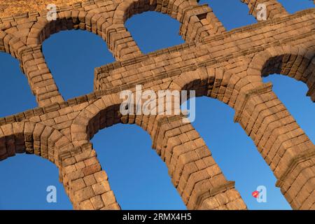 Spagna, Castiglia e León, Segovia, mongolfiera che passa davanti alla luce dorata del mattino presto dell'Acquedotto di Segovia, un acquedotto romano con Foto Stock