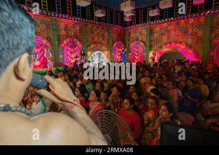 Howrah, Bengala Occidentale, India- 3 ottobre 2022 : Hindu purohit pronuncia shlokas sanscriti, guida i devoti per pushpanjali per pregare e adorare. Foto Stock