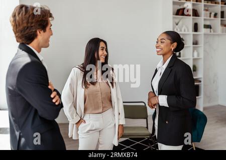 Giovani colleghi e impiegati multirazziali che lavorano in ufficio in sala conferenze e chiacchierano durante le pause Foto Stock