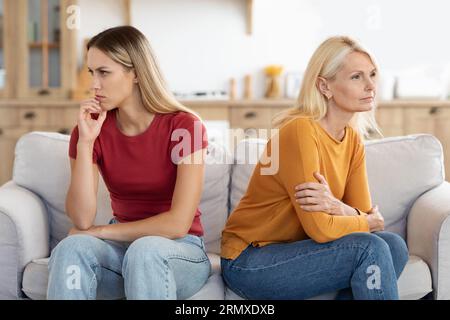 Offended millennial adult daughter and senior mother sit aside Foto Stock