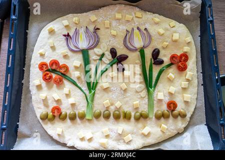 focaccia fatta in casa con verdure prima e dopo la cottura . Foto Stock