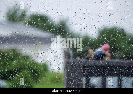 Vista all'esterno in una giornata di pioggia con gocce d'acqua sulla finestra. Foto Stock