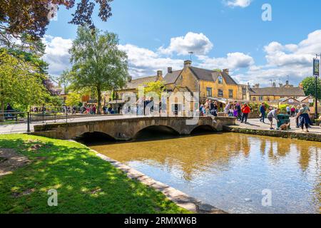 I pedoni camminano lungo il fiume Windrush presso la pittoresca Bourton-on-the-Water, un villaggio nella zona rurale di Cotswold, nel sud dell'Inghilterra centrale. Foto Stock