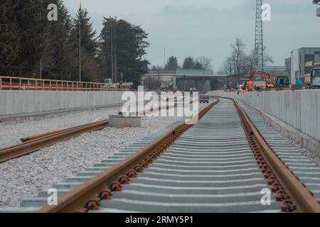 Modernizzazione della vecchia stazione ferroviaria di Domzale, città periferica di lubiana. Lavoratori che posano nuovi cingoli con ghiaia e nuova piattaforma pedonale. A guardare Foto Stock