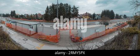 Modernization of older train station of Domzale, suburb city of ljubljana. Workers laying new tracks with gravel and new pedestrian platform. Wide pan Stock Photo