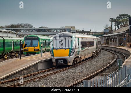 Treni sulla stazione di Drogheda macbride in irlanda, su una linea da Dublino a Belfast. Banchine ferroviarie e treni che passano in una giornata di sole. Foto Stock