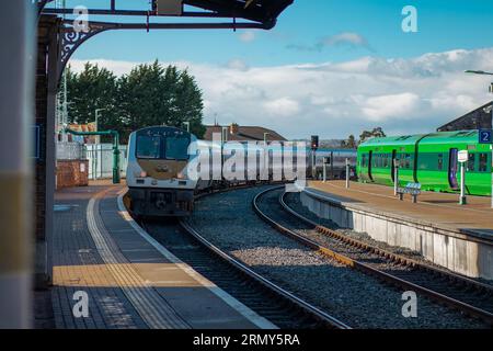 Treni sulla stazione di Drogheda macbride in irlanda, su una linea da Dublino a Belfast. Banchine ferroviarie e treni che passano in una giornata di sole. Foto Stock