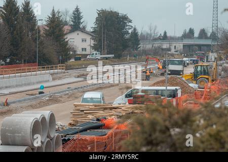 Modernizzazione della vecchia stazione ferroviaria di Domzale, città periferica di lubiana. Lavoratori che posano nuovi cingoli con ghiaia e nuova piattaforma pedonale. A guardare Foto Stock