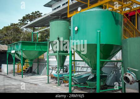 Big separators in green color for separating coffee seeds from outer skin. Coffee processing plant outside. Stock Photo