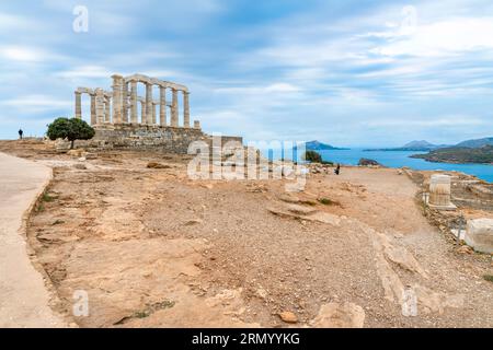 L'antico tempio di Poseidone sotto il cielo nuvoloso e suggestivo sulle colline di Capo Sunio sulla Riviera ateniese vicino ad Atene in Grecia. Foto Stock