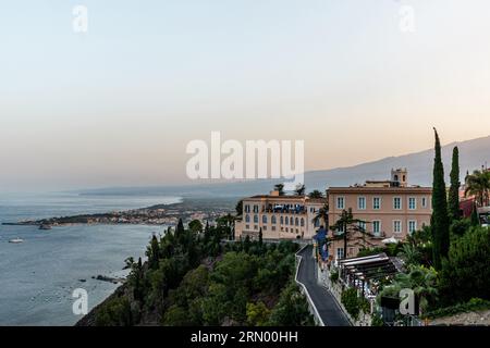 Edificio alberghiero a Taormina con alloggio per turisti vicino alla costa al tramonto Foto Stock