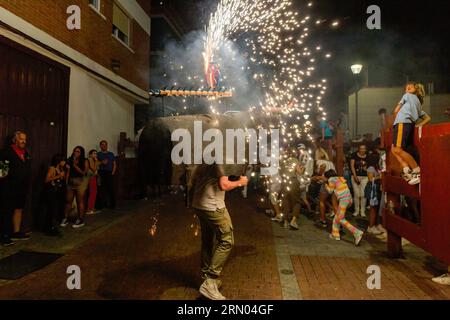 Madrid, Spagna. 30 agosto 2023. Un membro del gruppo El Remedio corre verso i partecipanti indossando un'armatura di toro con fuochi d'artificio, durante una piccola corrida attraverso una delle strade di San Sebastian de los Reyes. I festeggiamenti di San Sebastian de los Reyes, Madrid (Spagna), sono in onore del "Cristo de los Remedios" e tra i festeggiamenti ci sono la gestione dei tori, con più di 100 anni di antichità e dichiarati di interesse turistico nazionale. Credito: SOPA Images Limited/Alamy Live News Foto Stock