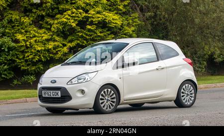 Whittlebury, Northants, Regno Unito - 27 agosto 2023: 2013 auto Ford Ka bianca che viaggia su una strada di campagna inglese Foto Stock