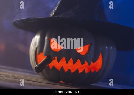 Zucca intagliata con cappello da strega su sfondo blu Foto Stock