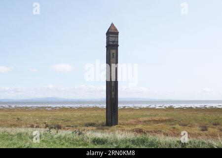 Rampside. Cumbria Inghilterra Regno Unito 30 agosto 2023 Rampside Lighthouse, Cumbria noto anche come The Needle costruito nel 1875, è l'unico esempio sopravvissuto di 13 fari costruiti intorno a Barrow durante la fine del XIX secolo per aiutare le navi nel porto di Barrow. È alto 20 metri (66 piedi) ed è costruito con mattoni rossi e gialli. Il faro di Rampside è stato designato edificio classificato di grado II dall'English Heritage nel 1991 ©Ged Noonan/Alamy Foto Stock