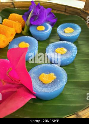 Snack dolci tailandesi di vario tipo e colore su foglia di banana con motivo intrecciato in ottone e metallo, ambientazione come tè pomeridiano o tè pomeridiano Foto Stock